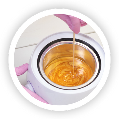 Hard wax used for professional hair removal on sensitive areas, melting in a wax warmer.